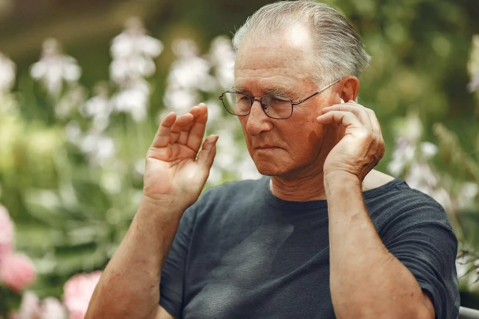 man touching ear - what is a hearing aid?
