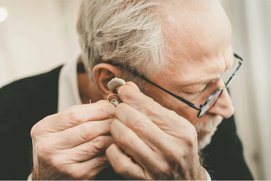 hearing improvements - man holding hearing aid