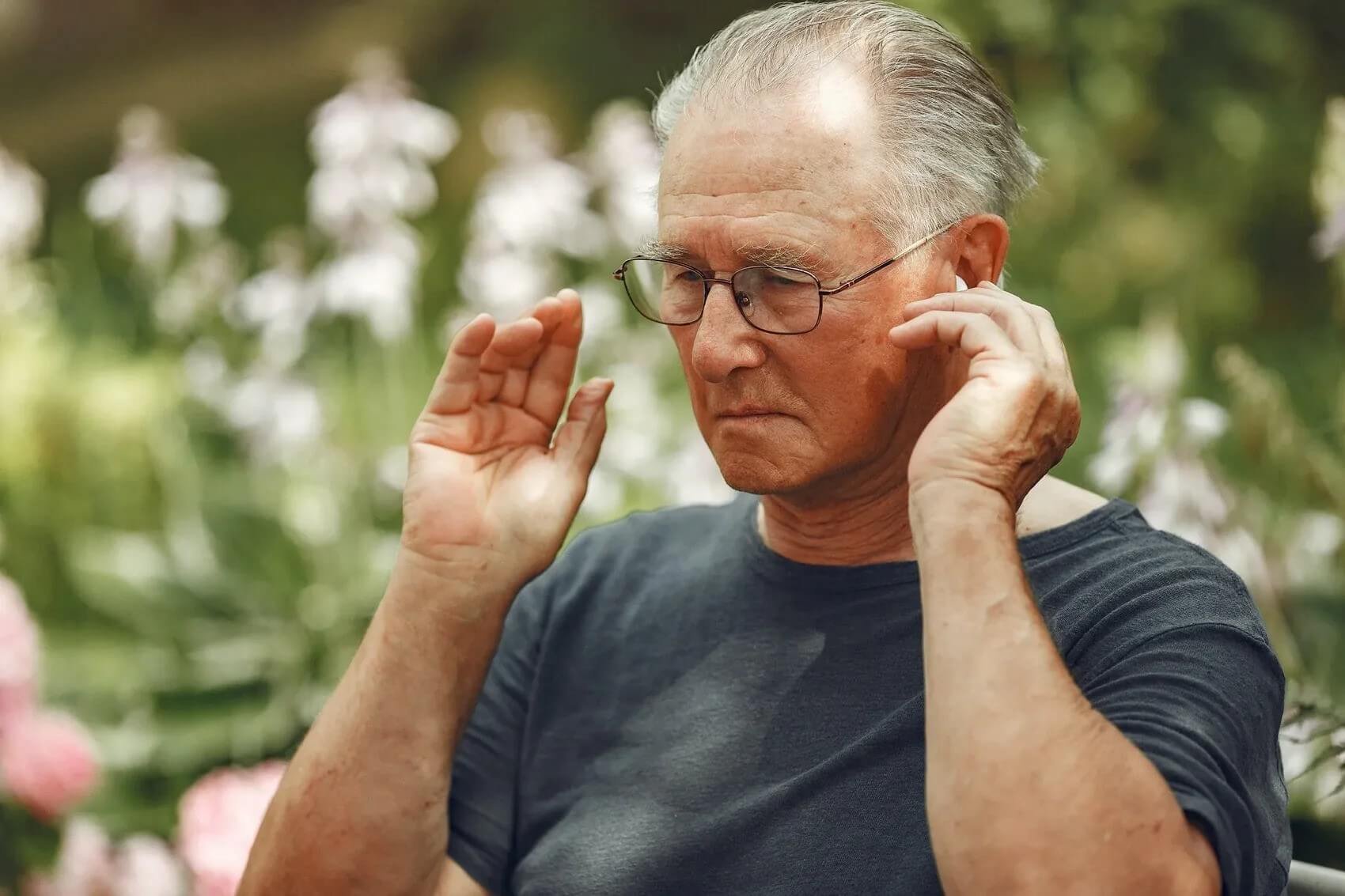 man touching ear - what is a hearing aid?
